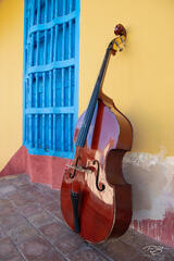 An upright bass leans against an old wall in Trinidad, Cuba
