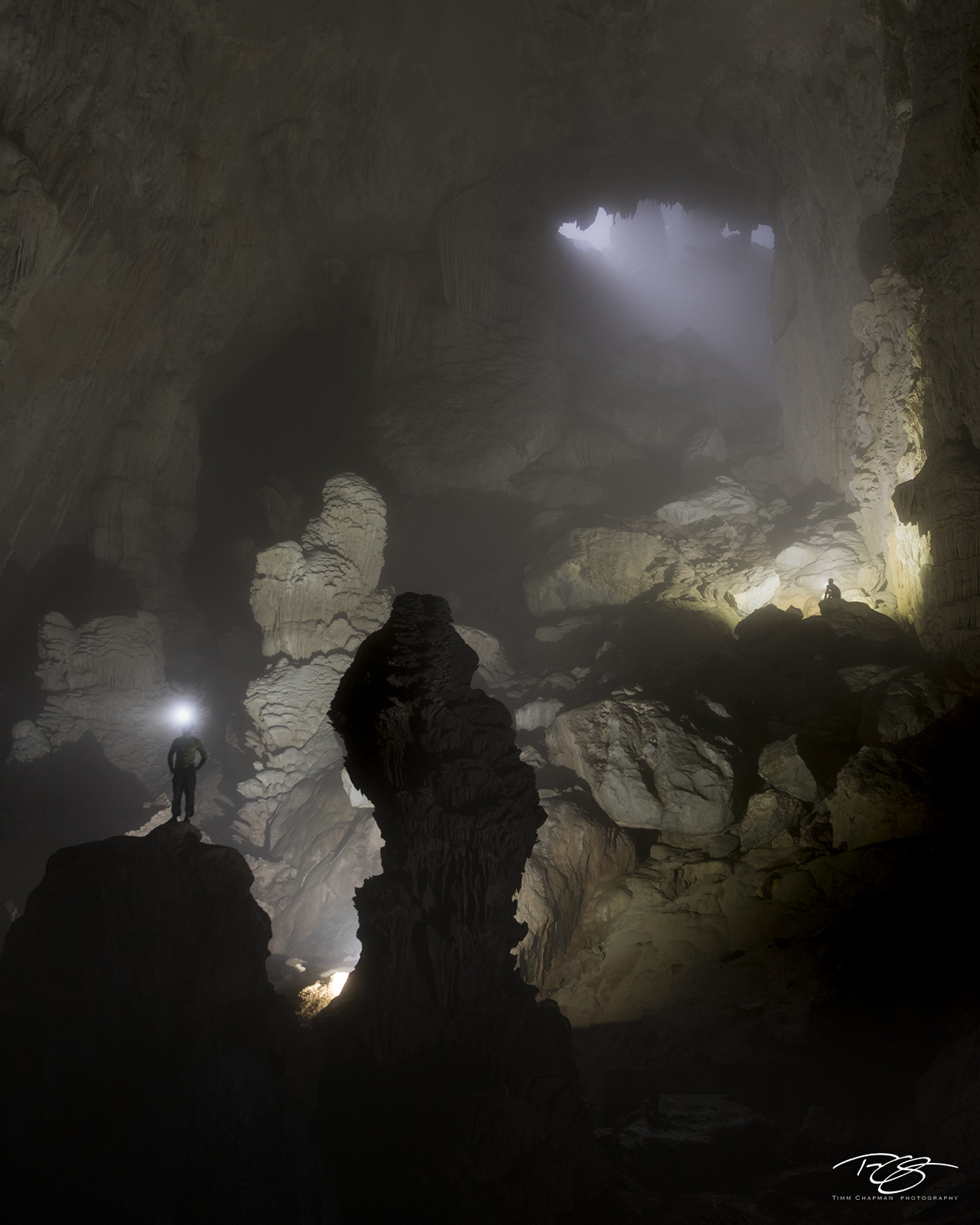 Hand of Dog A cave explorer looks into the dark depths below while standing next to the Hand of Dog formation inside Hang Son Ðoò...